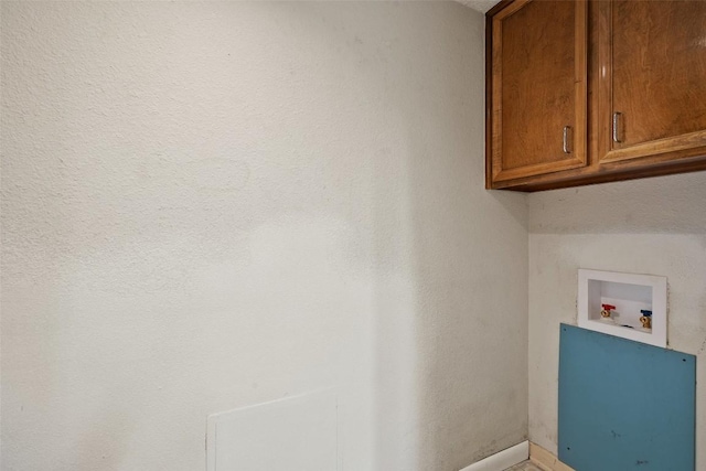 clothes washing area featuring cabinet space, washer hookup, and baseboards