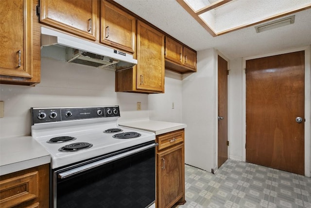 3317 William Cannon Dr Unit A, Austin, TX 78745 - kitchen featuring range with electric cooktop, under cabinet range hood, brown cabinets, light countertops, and light flooring