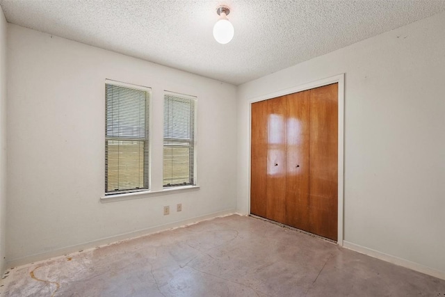 3317 William Cannon Dr Unit A, Austin, TX 78745 - unfurnished bedroom with concrete flooring, a textured ceiling, a closet, and baseboards