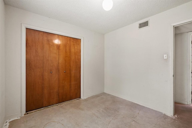 3317 William Cannon Dr Unit A, Austin, TX 78745 - unfurnished bedroom featuring a closet, unfinished concrete floors, and a textured ceiling