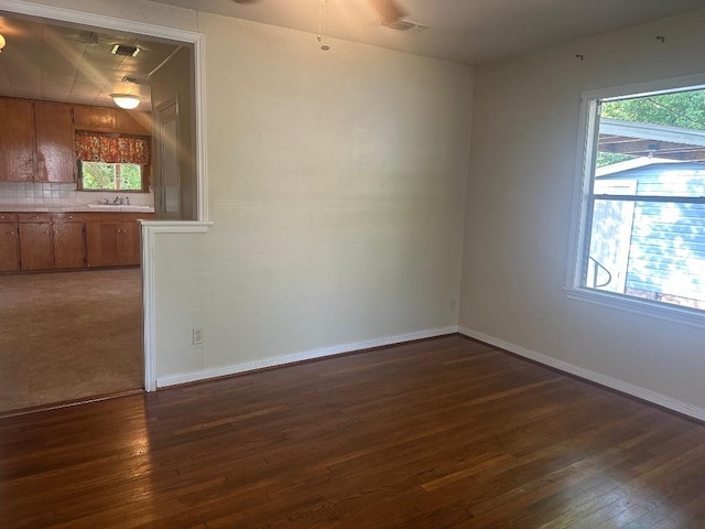 762 E Walnut St, La Grange, TX 78945 - unfurnished room featuring wood-type flooring, a sink, baseboards, and ceiling fan