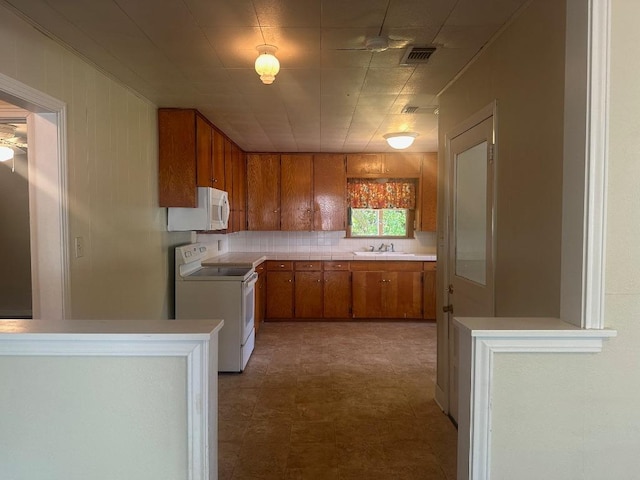 762 E Walnut St, La Grange, TX 78945 - kitchen featuring white appliances, brown cabinets, a sink, tile patterned floors, and light countertops