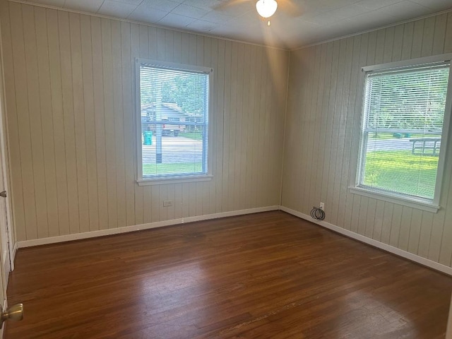 762 E Walnut St, La Grange, TX 78945 - unfurnished room featuring wood finished floors, healthy amount of natural light, baseboards, ceiling fan, and wooden walls