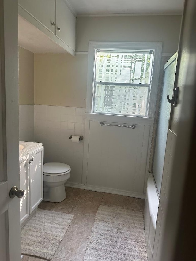 762 E Walnut St, La Grange, TX 78945 - bathroom featuring a shower with shower door, vanity, toilet, and tile walls