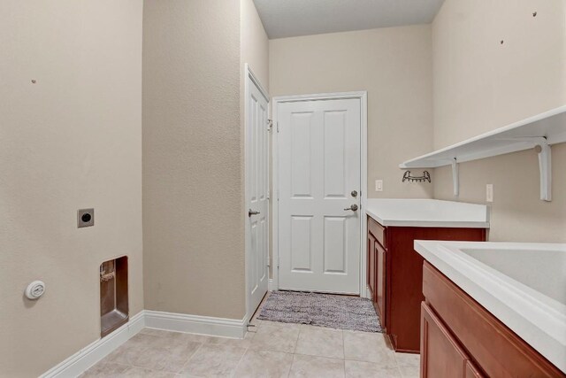 122 Coffee Mill Creek Rd, Georgetown, TX 78633 - laundry area with electric dryer hookup, light tile patterned floors, and baseboards