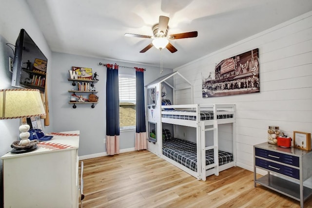 410 Easton Dr, San Marcos, TX 78666 - bedroom featuring light wood-type flooring, wooden walls, a ceiling fan, and baseboards