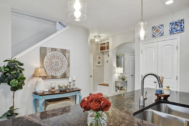 410 Easton Dr, San Marcos, TX 78666 - kitchen with a sink, arched walkways, dark stone counters, and pendant lighting