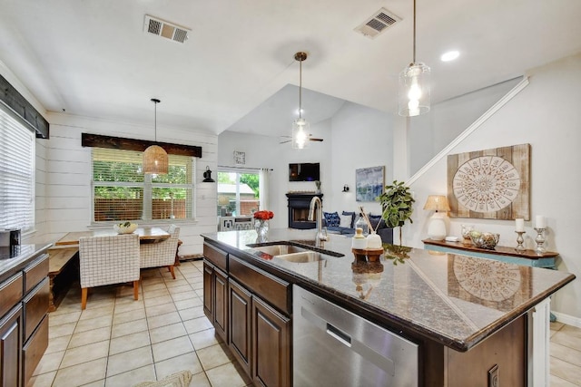 410 Easton Dr, San Marcos, TX 78666 - kitchen with dishwasher, a sink, a fireplace, light tile patterned floors, and dark brown cabinetry