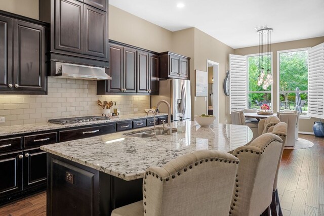 285 Sand Hills Ln, Austin, TX 78737 - kitchen featuring a sink, appliances with stainless steel finishes, a kitchen breakfast bar, dark wood-style floors, and tasteful backsplash