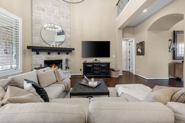285 Sand Hills Ln, Austin, TX 78737 - living room featuring dark wood-type flooring, baseboards, a towering ceiling, a fireplace, and arched walkways