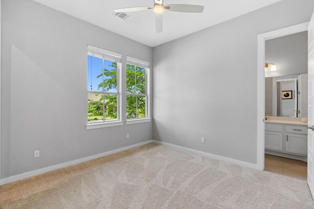 716 Dayridge Dr, Dripping Springs, TX 78620 - unfurnished bedroom with light colored carpet, baseboards, connected bathroom, and ceiling fan