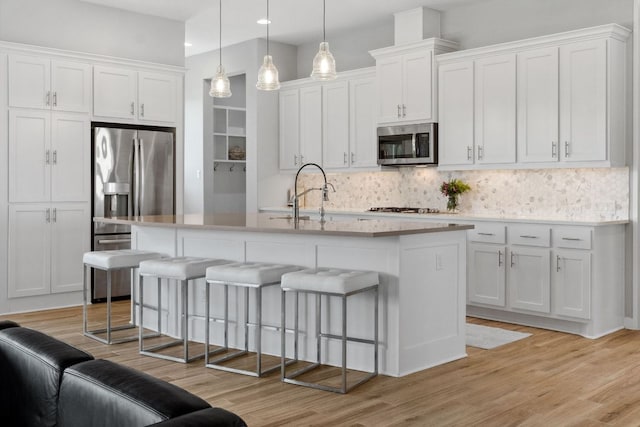 716 Dayridge Dr, Dripping Springs, TX 78620 - kitchen with stainless steel appliances, a breakfast bar, tasteful backsplash, white cabinets, and recessed lighting