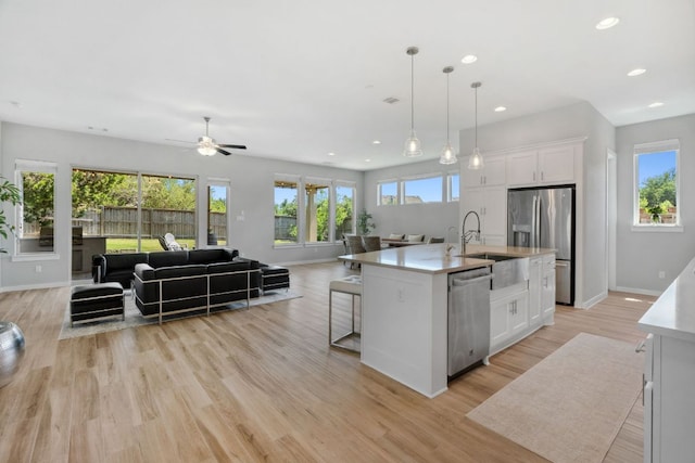 716 Dayridge Dr, Dripping Springs, TX 78620 - kitchen featuring stainless steel appliances, open floor plan, white cabinets, a ceiling fan, and light countertops