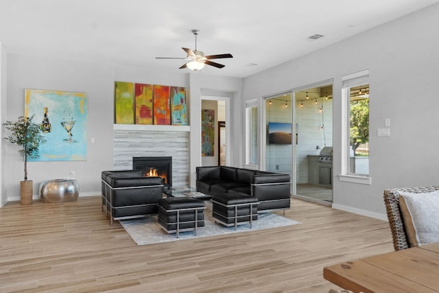 716 Dayridge Dr, Dripping Springs, TX 78620 - living room featuring a fireplace, light wood-style floors, baseboards, and a ceiling fan