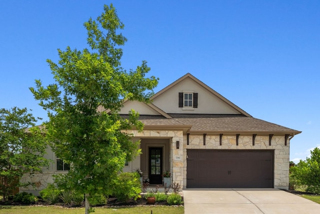716 Dayridge Dr, Dripping Springs, TX 78620 - view of front of property with stone siding, an attached garage, driveway, stucco siding, and roof with shingles