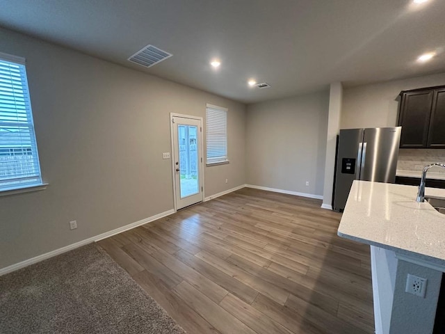 152 Mason Hill Ln, Georgetown, TX 78628 - kitchen with stainless steel fridge with ice dispenser, wood finished floors, baseboards, light stone countertops, and recessed lighting