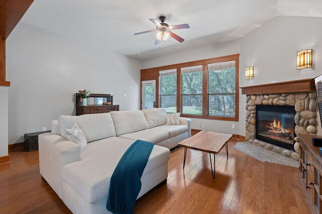 11036 Cherisse Dr, Austin, TX 78739 - living room with a stone fireplace, wood-type flooring, a ceiling fan, and baseboards