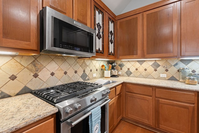 11036 Cherisse Dr, Austin, TX 78739 - kitchen with stainless steel appliances, brown cabinets, and light stone counters