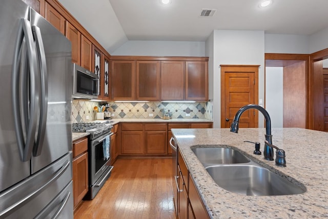 11036 Cherisse Dr, Austin, TX 78739 - kitchen featuring stainless steel appliances, a sink, light stone countertops, light wood-type flooring, and recessed lighting