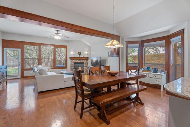 11036 Cherisse Dr, Austin, TX 78739 - dining area with a stone fireplace, vaulted ceiling, wood-type flooring, and plenty of natural light