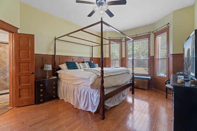 11036 Cherisse Dr, Austin, TX 78739 - bedroom with wainscoting, wood finished floors, wood walls, and a ceiling fan