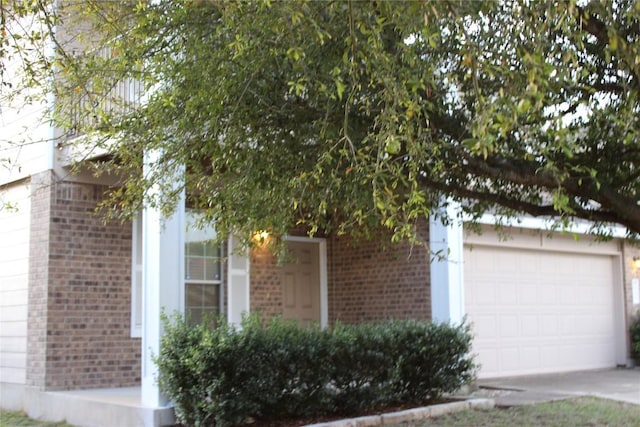 view of front of property featuring brick siding, concrete driveway, and an attached garage