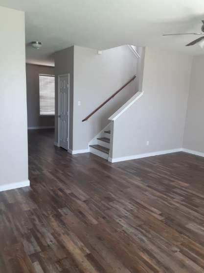 spare room with a ceiling fan, stairway, dark wood finished floors, and baseboards