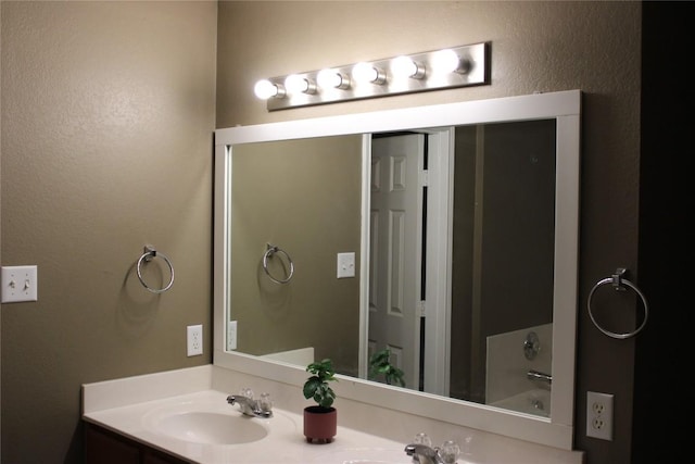 full bath with double vanity and a bath