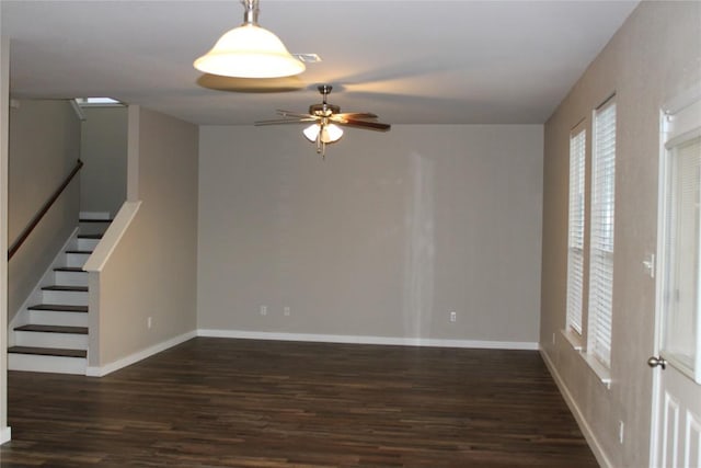 spare room featuring wood finished floors, a ceiling fan, healthy amount of natural light, and baseboards