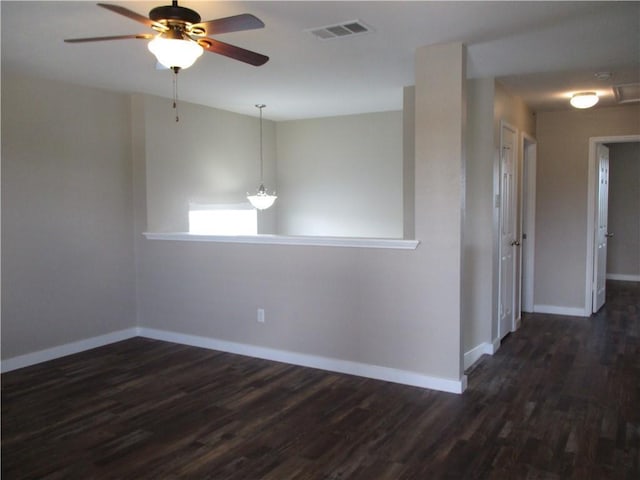 empty room with ceiling fan, dark wood-style flooring, and baseboards