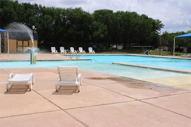 community pool featuring fence and a patio area