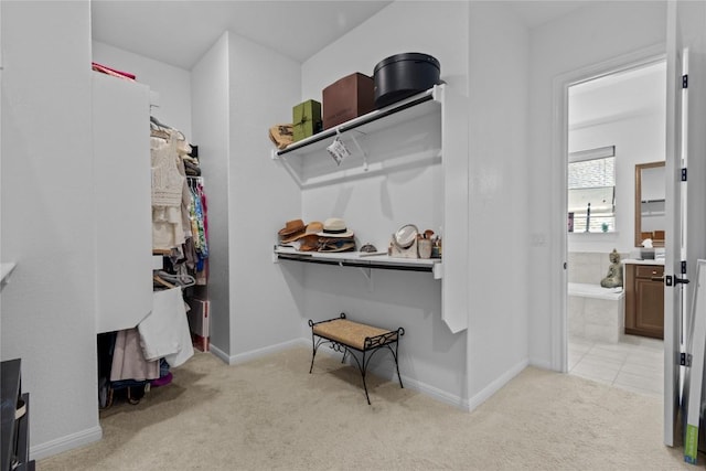 walk in closet featuring light carpet