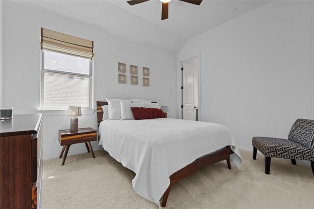 bedroom with light colored carpet, vaulted ceiling, baseboards, and ceiling fan