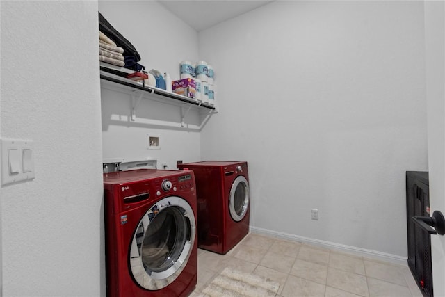 clothes washing area with independent washer and dryer, baseboards, and light tile patterned floors