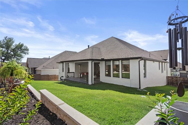 back of house with a shingled roof, a patio, and brick siding