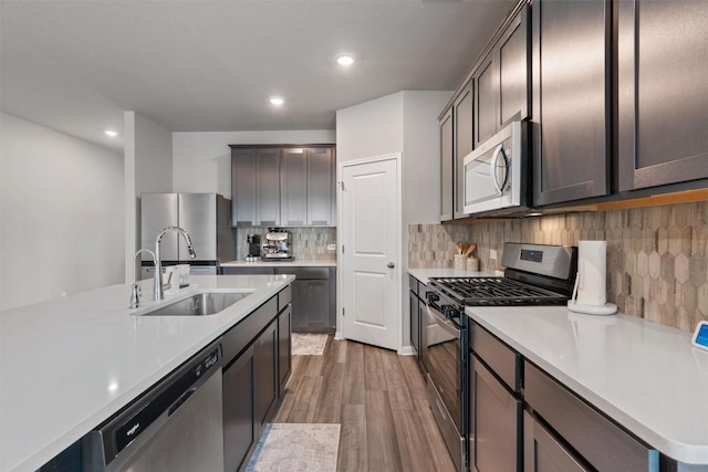 503 Windy Reed Rd, Hutto, TX 78634 - kitchen with appliances with stainless steel finishes, light wood-style flooring, light countertops, recessed lighting, and tasteful backsplash