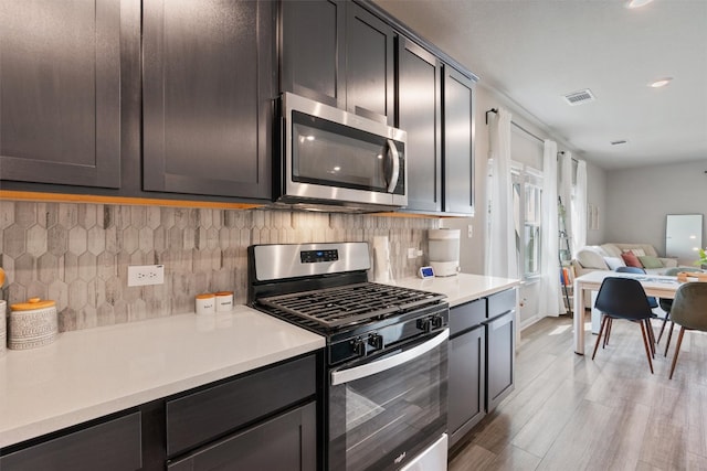 503 Windy Reed Rd, Hutto, TX 78634 - kitchen featuring appliances with stainless steel finishes, open floor plan, light countertops, light wood-type flooring, and recessed lighting
