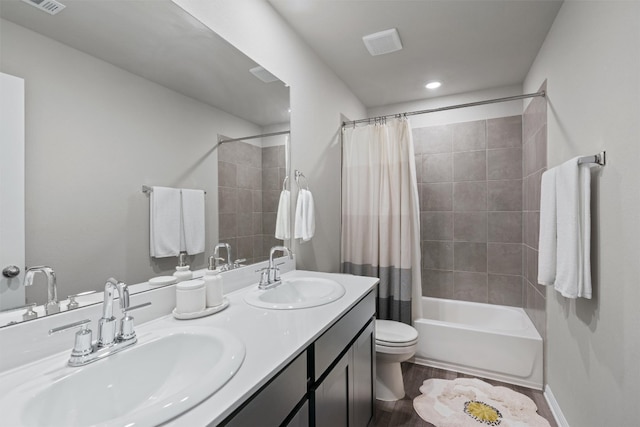 503 Windy Reed Rd, Hutto, TX 78634 - bathroom featuring shower / bath combination with curtain, double vanity, toilet, wood finished floors, and recessed lighting