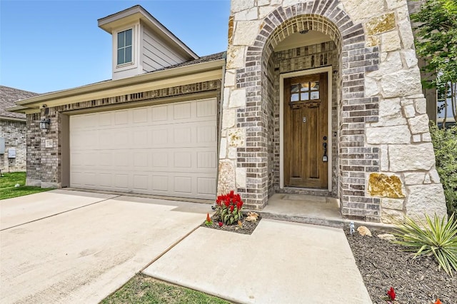 552 Windom Way, Georgetown, TX 78626 - view of exterior entry featuring driveway, a garage, brick siding, and stone siding