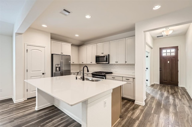 552 Windom Way, Georgetown, TX 78626 - kitchen featuring appliances with stainless steel finishes, a sink, dark wood-type flooring, a center island with sink, and recessed lighting