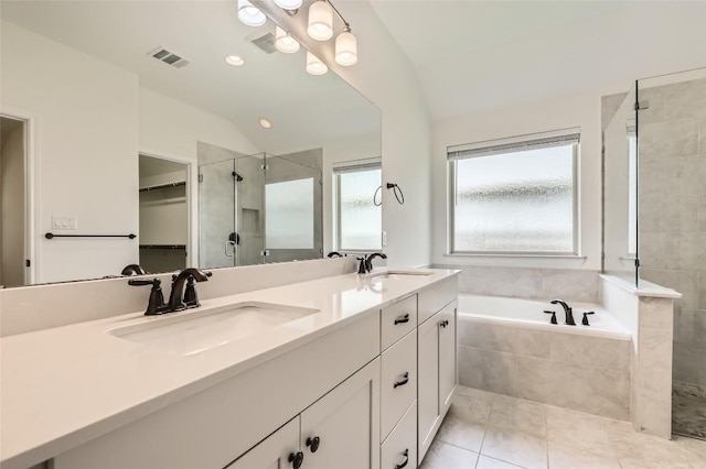 552 Windom Way, Georgetown, TX 78626 - bathroom featuring a stall shower, double vanity, vaulted ceiling, a garden tub, and a spacious closet