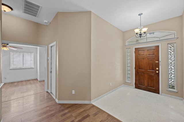 foyer with a chandelier, wood finished floors, a ceiling fan, and baseboards