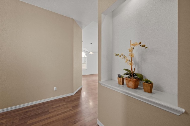 corridor with wood finished floors and baseboards