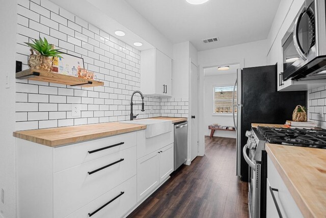 5916 Signal Pt, Austin, TX 78724 - kitchen with butcher block countertops, stainless steel appliances, a sink, tasteful backsplash, and recessed lighting