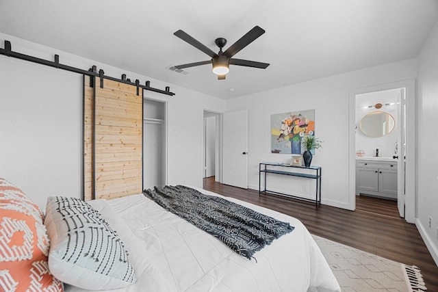 5916 Signal Pt, Austin, TX 78724 - bedroom with wood finished floors, a barn door, baseboards, a closet, and a ceiling fan
