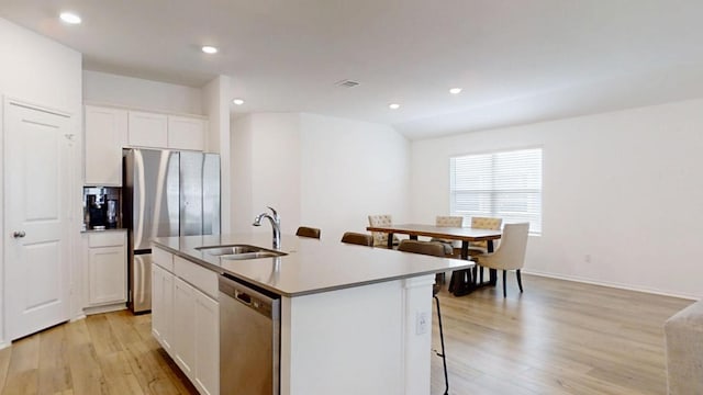 221 Mendoza, Kyle, TX 78640 - kitchen featuring appliances with stainless steel finishes, a sink, light wood-style flooring, an island with sink, and recessed lighting