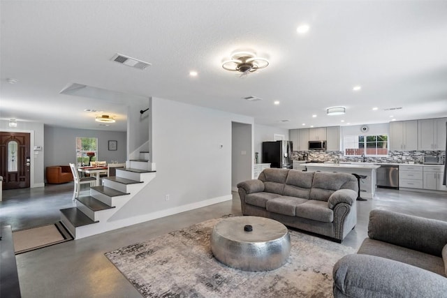 361 Whispering Hollow Dr, Kyle, TX 78640 - living area featuring concrete floors, stairway, recessed lighting, and baseboards