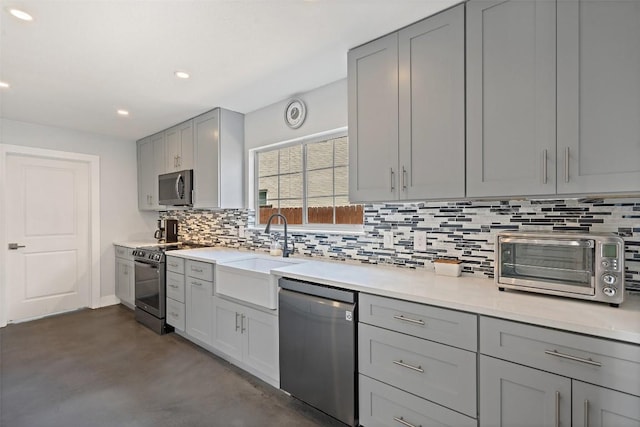 361 Whispering Hollow Dr, Kyle, TX 78640 - kitchen with appliances with stainless steel finishes, gray cabinets, tasteful backsplash, a sink, and recessed lighting