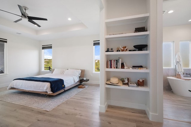 20704 Leaning Oak Dr, Lago Vista, TX 78645 - bedroom featuring wood finished floors, a tray ceiling, recessed lighting, and ceiling fan