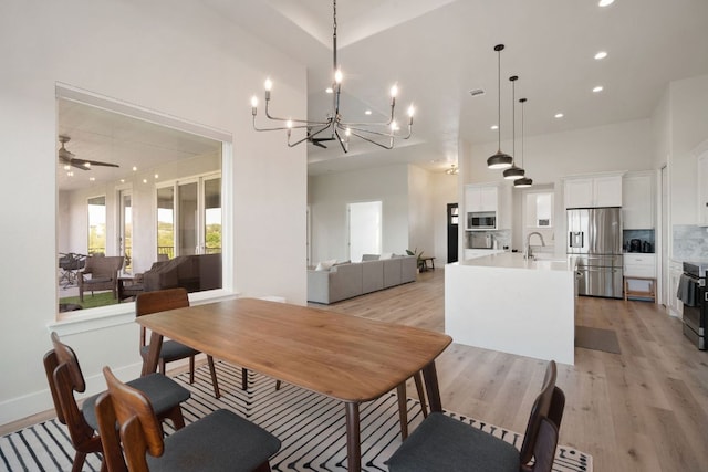20704 Leaning Oak Dr, Lago Vista, TX 78645 - dining space with a chandelier, light wood-style flooring, recessed lighting, a towering ceiling, and a ceiling fan